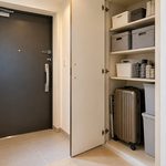 マンションの玄関横の収納スペースに収めたスーツケースと収納ケース